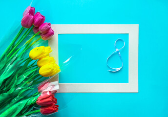 Fresh bouquets of tulips flowers on light blue background. Woman's Day 8 March greeting card.