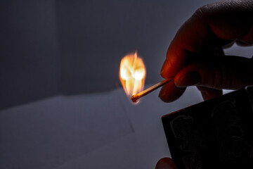 Photo of a burning match with a yellow flame