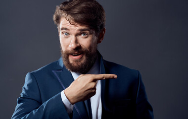A bearded man in a suit close-up studio dark background businessman