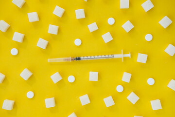 sugar and a syringe on a yellow background . risk of diabetes