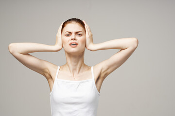 woman in white t-shirt emotions displeasure ear problems studio