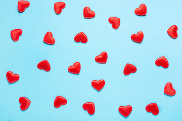 Valentine's Day concept, red small hearts on a blue background, horizontal orientation, flat lay