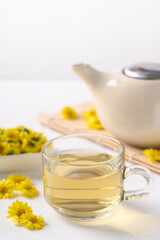 Organic Chrysanthemum flower tea in a cup and teapot on white background, Healthy Herbal drink