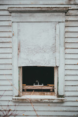 Old broken window on a saltbox home in newfoundland