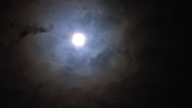 Full Moon Moving Behind Flying Clouds. 4K Timelapse footage.