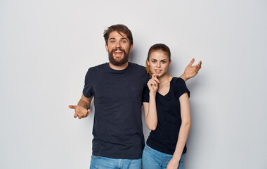 cheerful man and woman in black t-shirts studio casual clothes isolated background