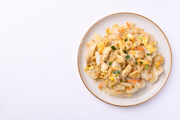 Thai food (Kuaitiao Khua Kai), Stir fried rice noodles with egg and chicken on white background, top view