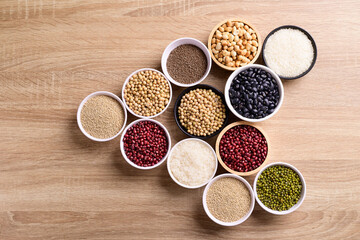 Various cereal grain in a bowl on wooden background (quinoa seeds, black kidney bean, peanut, perilla seeds, soybean, azuki beans, rice grain and mung beans)