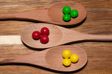 Three wood spoons with colorful candies