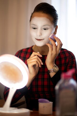 mime girl in front of the mirror smiles and applies makeup