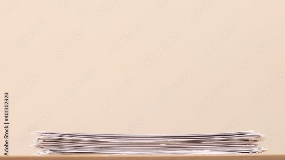 Fototapete Stack of overload document paper on wooden table - Stop motion animation. Business concept footage.