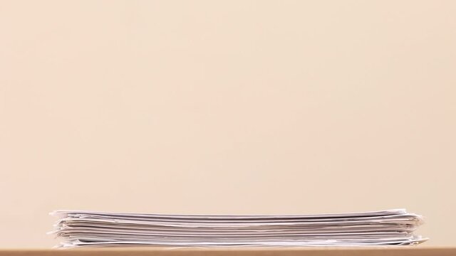 Stack of overload document paper on wooden table - Stop motion animation. Business concept footage.