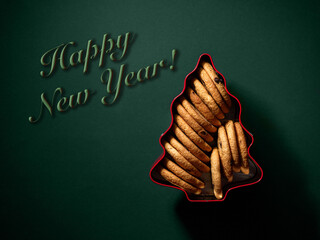 Cookies in a box for the holiday with the inscription happy new year on a green background.