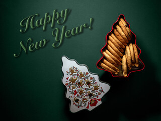 Cookies in a box with an open lid for the holiday with the inscription happy new year on a green background.