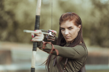 Portrait of young woman archery on forest background