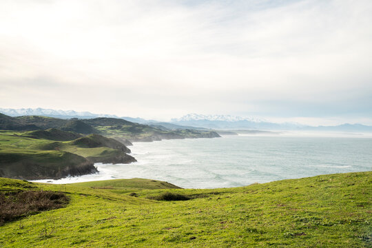 Beautiful view of a cliff green hill and the waves