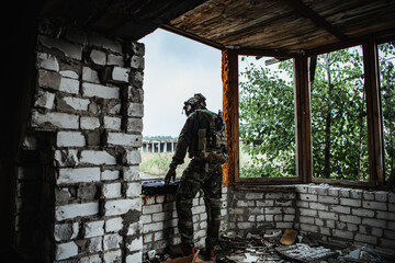 Fototapeta premium The soldier pulls a rifle out of the ammunition case and insert ammunition clip into assault rifle