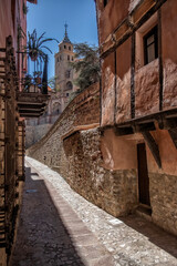 paved street in the medieval city of Albarracin in the province of Teruel, Aragon Spain in a sunny day, the cathedral of Albarracin in the background