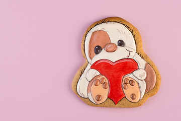 Gingerbread shaped as sloth with big red heart in his arms, ginger cookies on a pink background