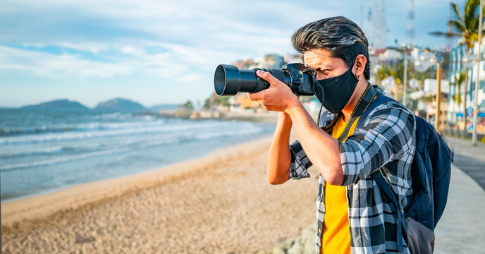 joven fotógrafo latino en playa  