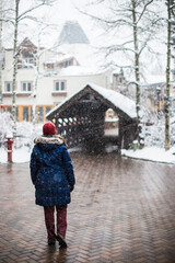 A woman walking into Vail village on a cold, snowy and wintery day in Vail, Colorado, USA
