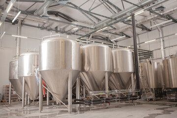 Rows of metal beer tanks at microbrewery, copy space