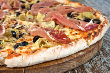 Pizza with Serrano ham, mushrooms and sliced black olives