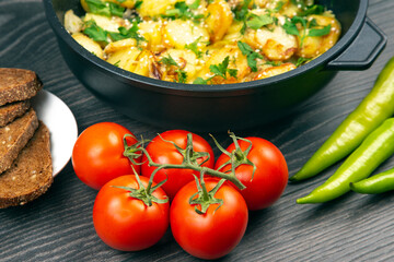 red tomatoes and green hot peppers on a kitchen board