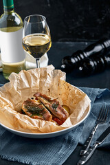 Fish pies and vegetables in craft paper on plate, restaurant giving. Style rustic. Selective focus.