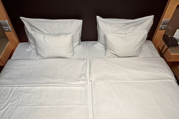 Double bed in a hotel room, white bed linen