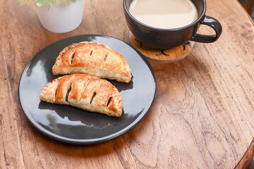 Close view of red bean puff with a cup of coffee on the wooden table