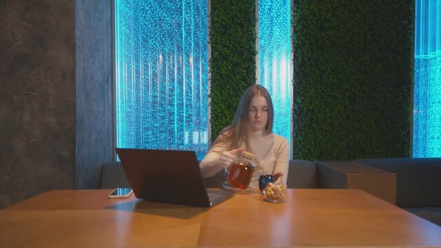 Young business woman sitting in cafe with laptop. Woman dring tea and working