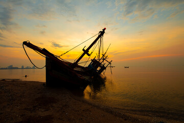 Seascape silhouette fisherman Shipwreck against sunset sky