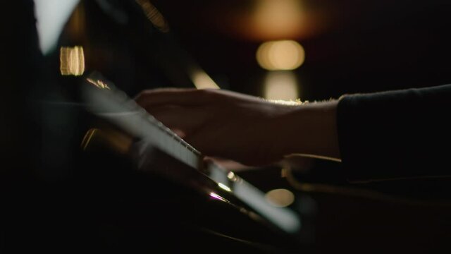 Female pianist plays In Grand Piano On Stage. Black background. Close Up hand.
