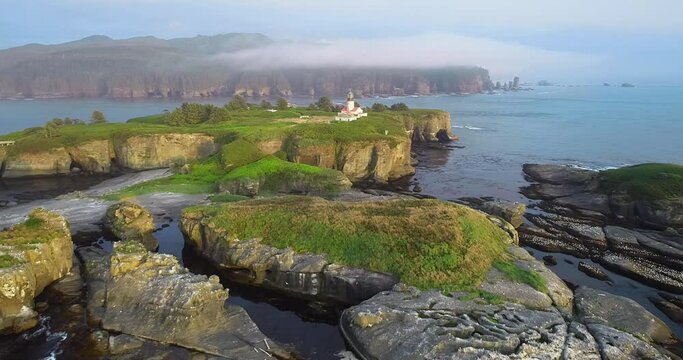 Flying 2 miles West on tip of Washington State called Cape Flattery. Sun going down over lighthouse