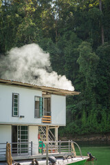 Houseboat cruising through the lake with mountain view at Kenyir Lake. Tasik Kenyir is a man-made lake.