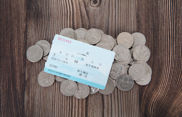 Train ticket on a pile of coins