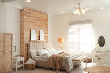 Stylish bedroom interior with modern ceiling fan and comfortable bench