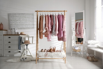 Rack with stylish women's clothes indoors. Interior design