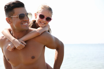 Fototapeta premium Father playing with daughter at beach. Family vacation