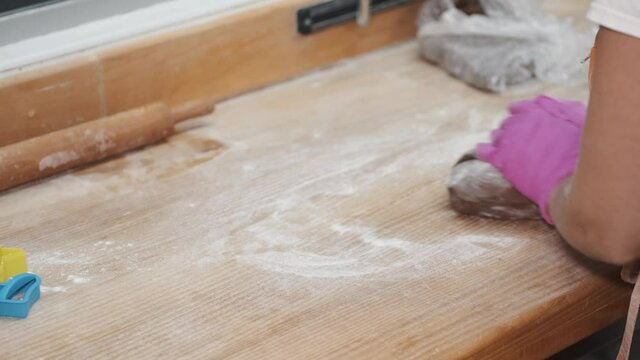 Slow Motion shot of bakery chef kneeding dough on wooden table. Baking concept.