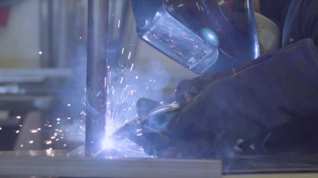 Metal worker welding pieces of metal with mig, 4k super slow motion