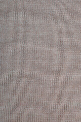 Obraz na płótnie Canvas Light brown wool knitted canvas, hand knit, plain knitting, clouseup, vertical photo