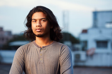 Young man portrait with long hair in evening light