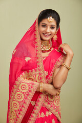 Beautiful smiling Indian bride with jewelry in studio shot.