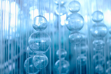Abstract glass balls hang on threads.