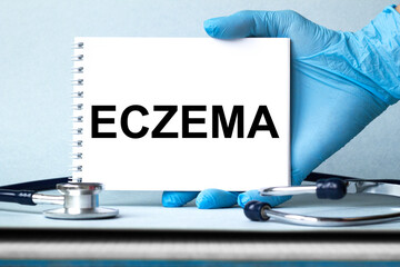 The doctor's hands show the word ECZEMA . a gloved hand on a white background. Medical concept. the medicine