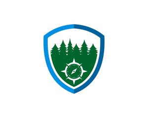 Fototapeta premium Protection shield with compass and pine forest