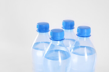 Plastic bottles with pure water on white background, closeup