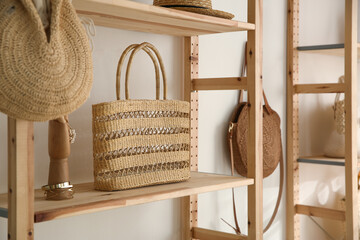 Stylish woman's bag and jewelries on shelf in boutique